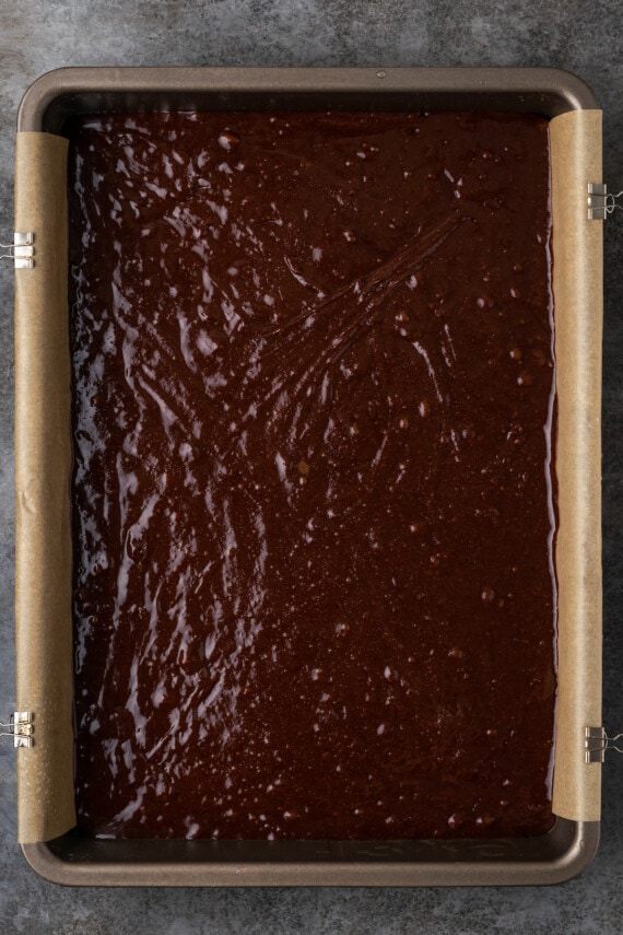 Brownie batter in a parchment-lined baking pan.