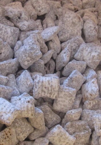 Close-up view of a batch of Muddy Buddies coated in powdered sugar