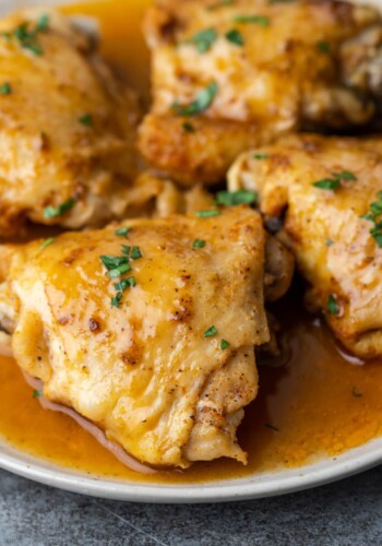 Close up of instant pot chicken thighs on a plate smothered with gravy.
