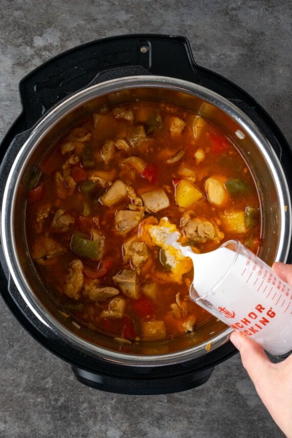 A cornstarch slurry is poured into Hawaiian chicken in the Instant Pot.