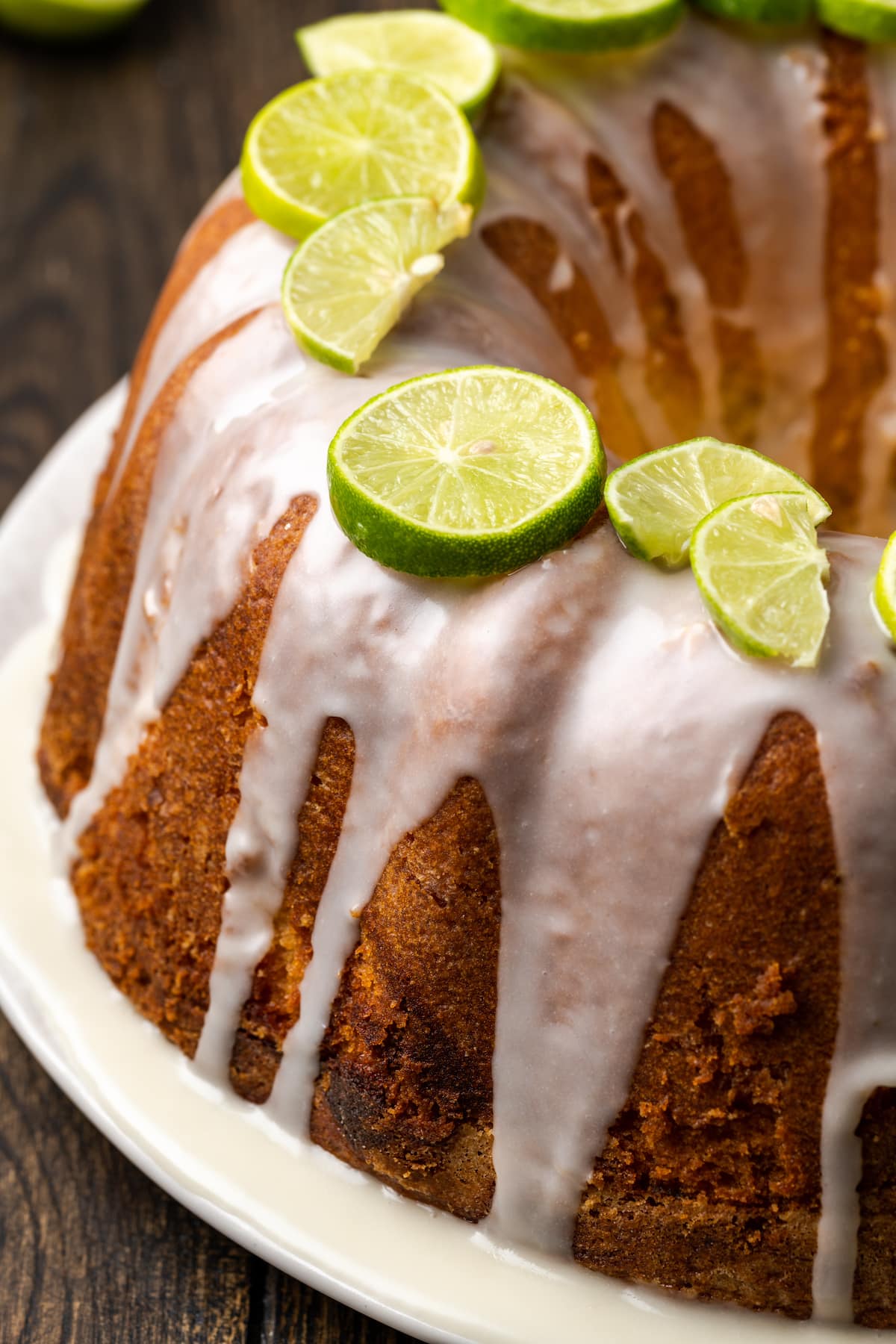 Close up view of Key lime pound cake drizzled with icing and garnished with fresh limes.