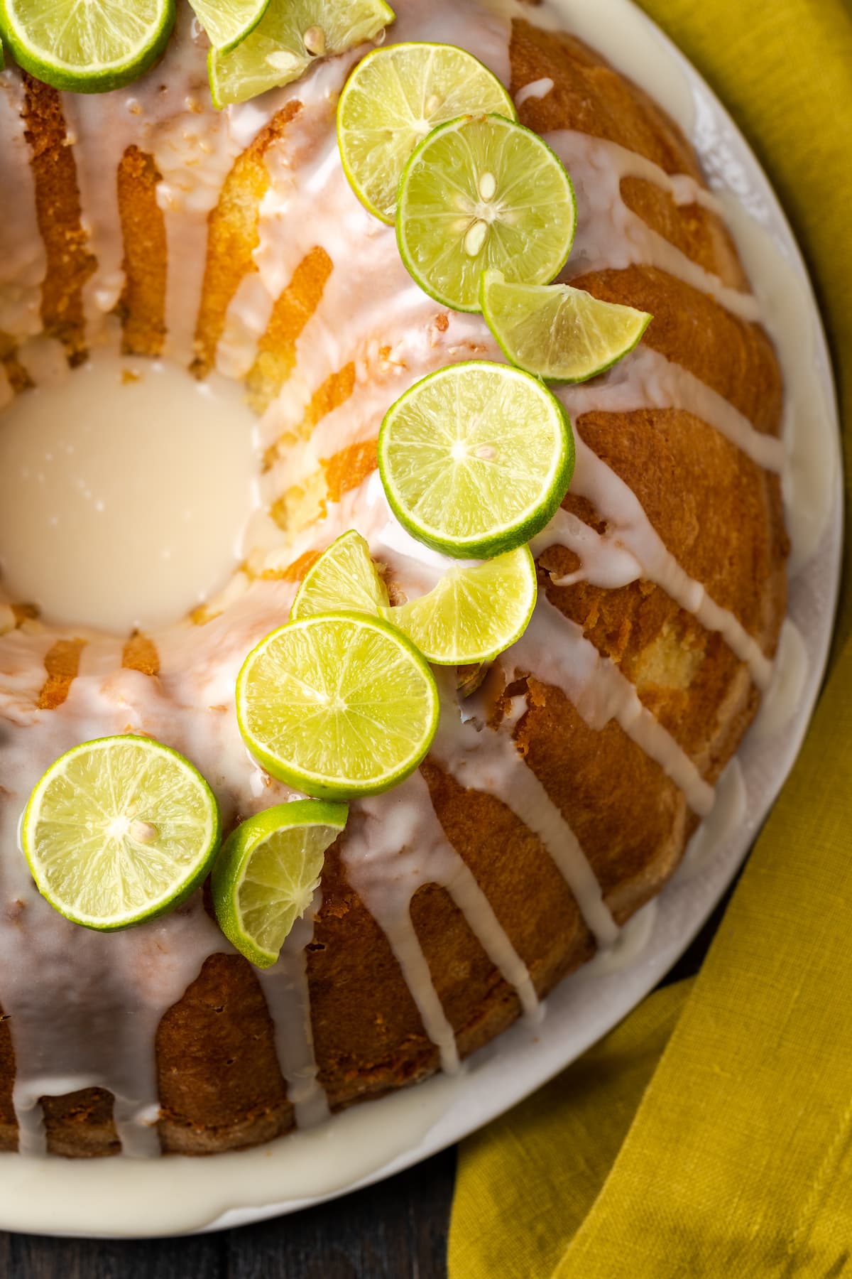 Overhead view of a full Key lime pound cake drizzled with icing and garnished with fresh limes.