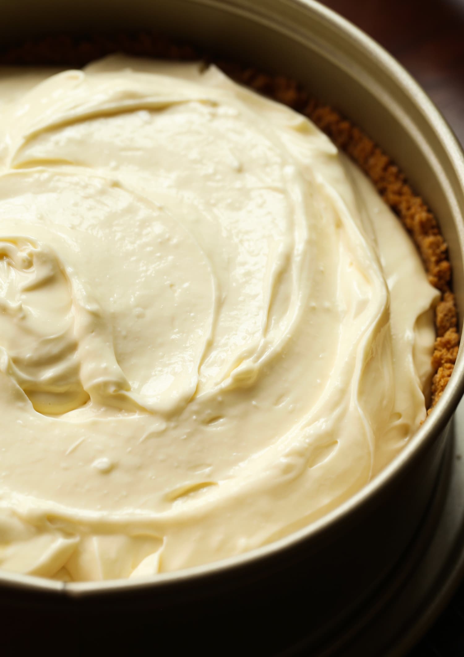 Cheesecake filling poured into a pan filled with graham cracker crust.