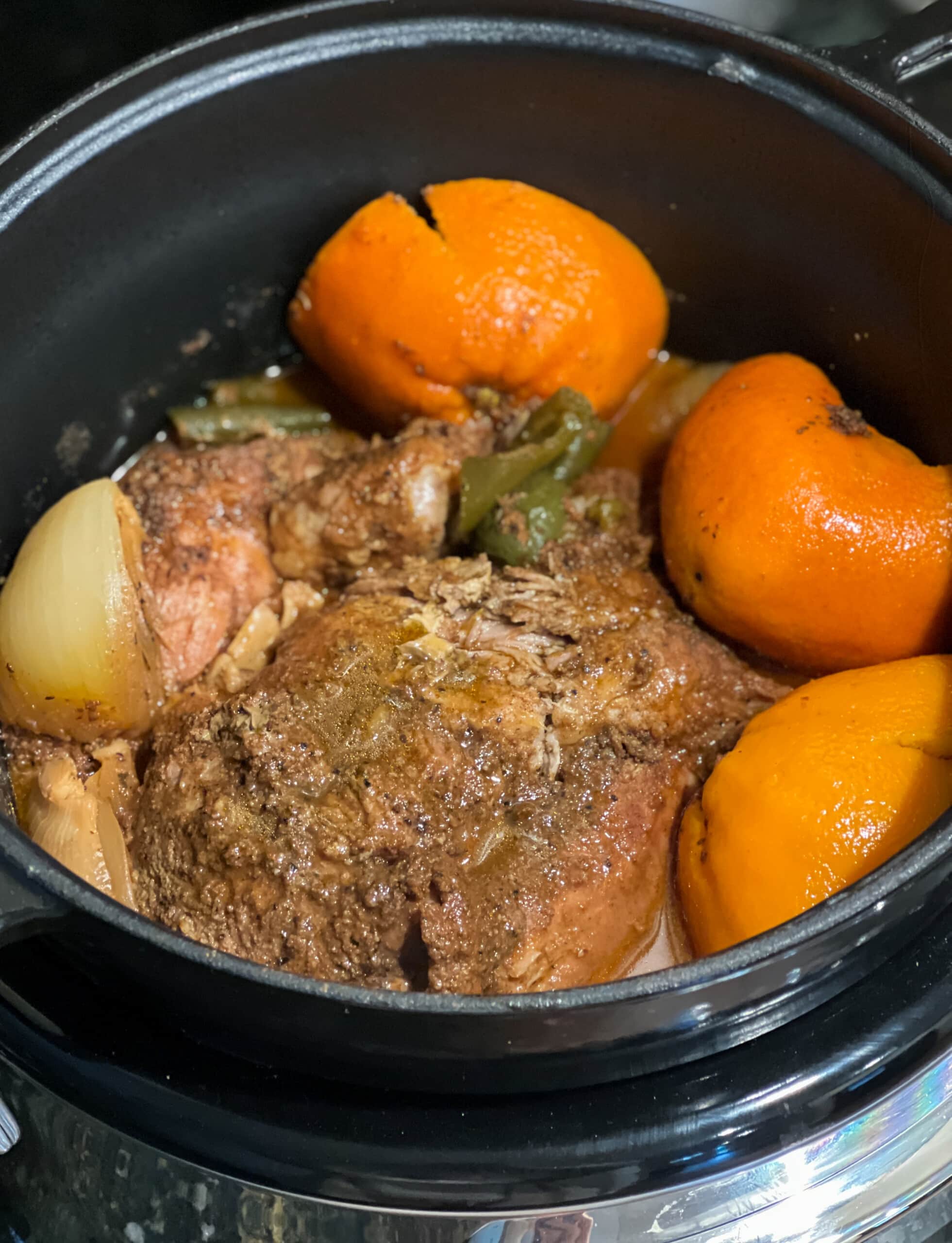pork carnitas ingredients in a slow cooker before it's cooked