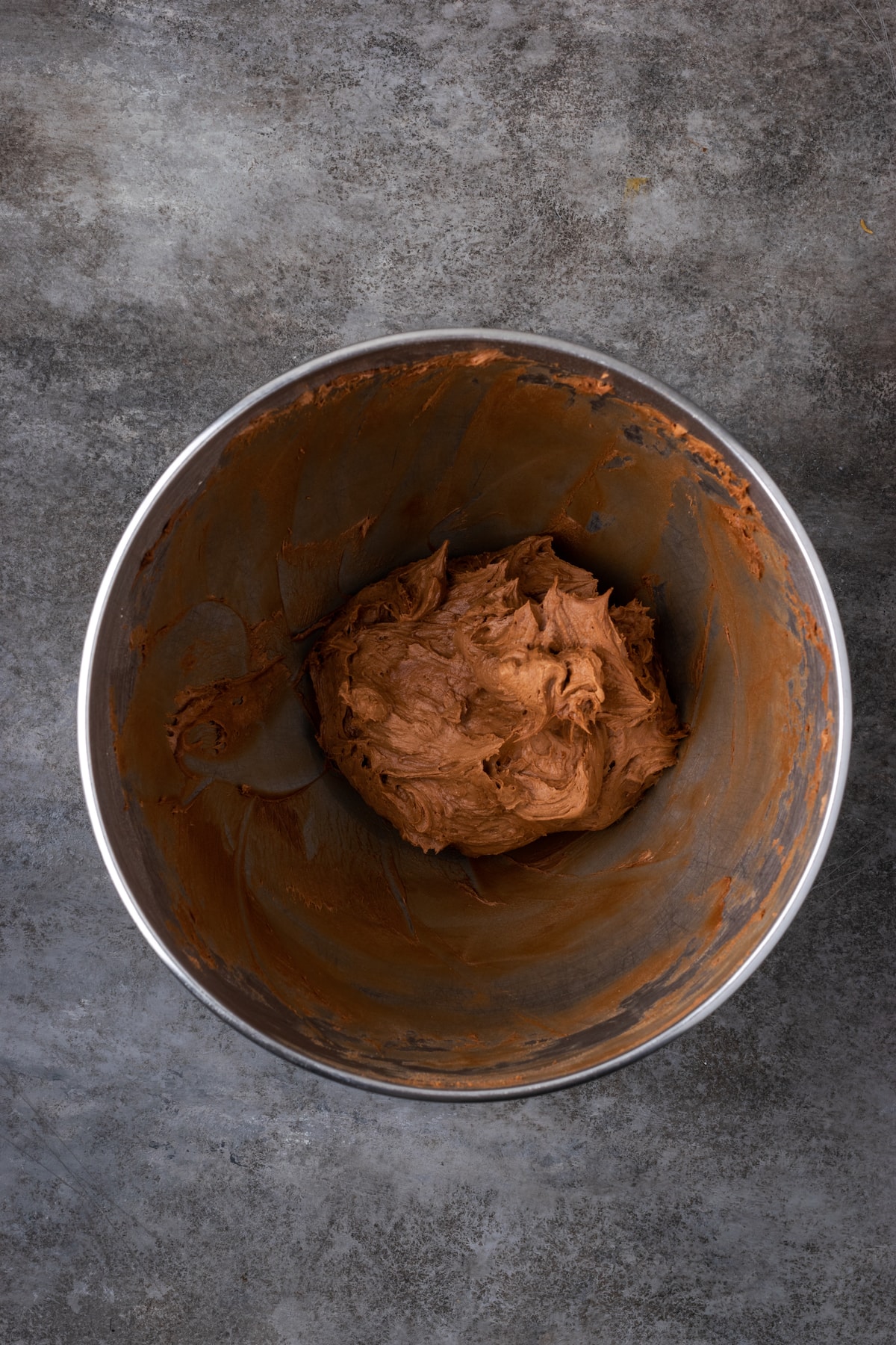 Creamy chocolate frosting in a mixing bowl.