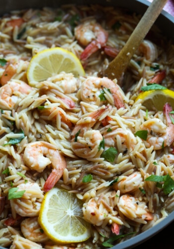 Shrimp orzo in a skillet with lemons.