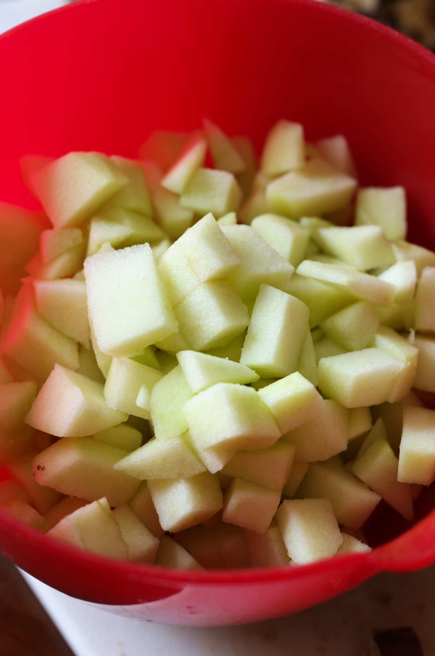 chopped granny smith apples in a red bowl