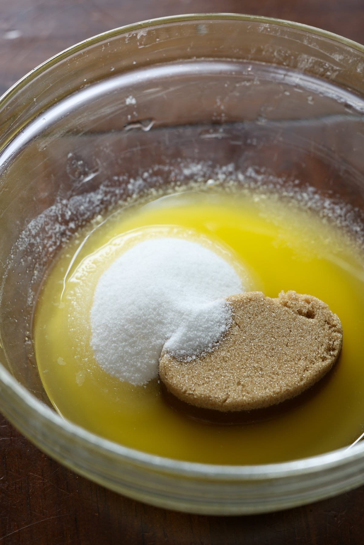 melted butter, granulated sugar, and light brown sugar in a clear glass bowl